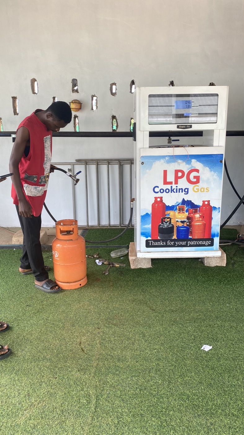 Signature Oil and Gas attendant refilling a customer's LPG cylinder at the dispenser